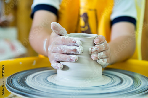 Young boy making a pitcher of clay photo