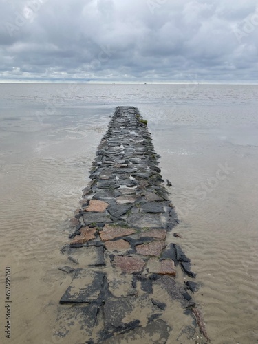 Landschaft an der Nordsee mit Mole aus Steinen bei mystischem Licht