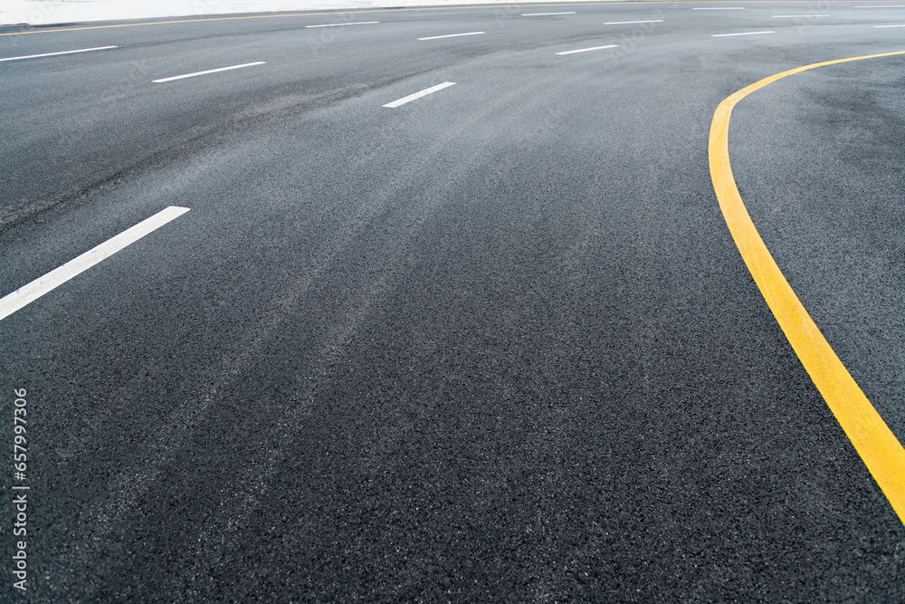 Asphalt road with white stripes and yellow lines