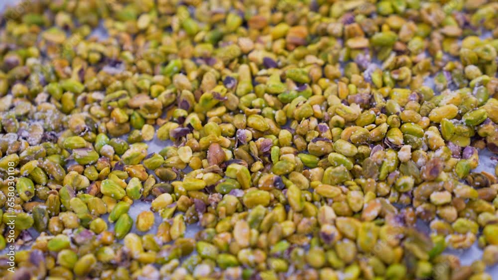 Shelled pistachios roasted with salt on a tray. Whole nut kernels. Shelled pistachios roasted with salt on a tray. Whole nut kernels.