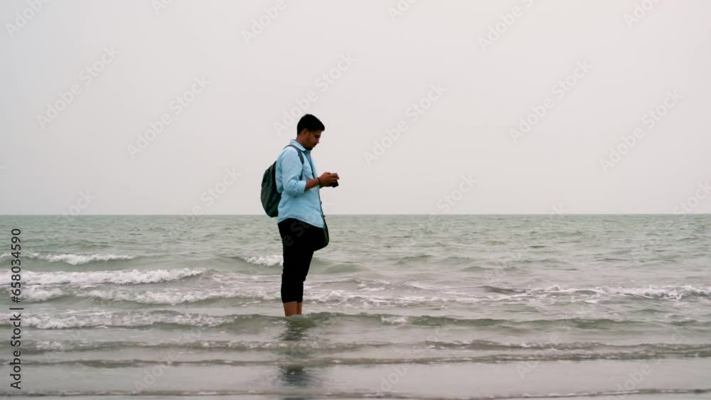 Photographer taking picture at sea shore in Kuakata, Bangladesh. Tourists in bay of bengal sea
