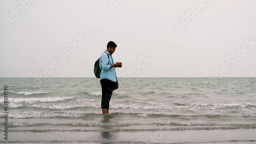 Photographer taking picture at sea shore in Kuakata, Bangladesh. Tourists in bay of bengal sea photo