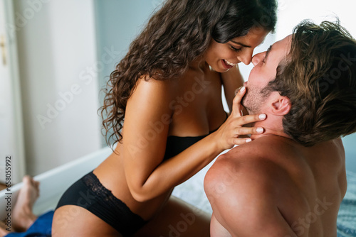 Loving couple having intimate moments in bedroom. People sexual relationship concept.