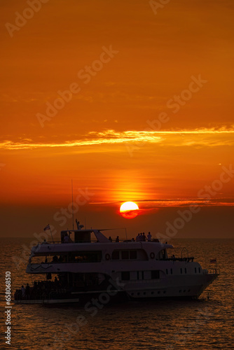 Beautiful wide twilight sunset evening sky reflect on sea water with silhouette boat in ocean and epic cloud pattern background landscape with love, peace and loneliness mood vibes on vacation trip.