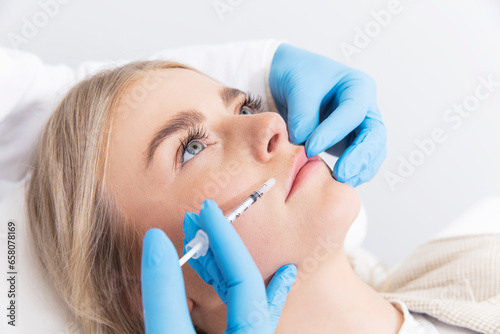 doctor with a syringe injecting patient with botox photo