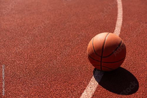 Orange basketball on court of gymnasium sport floor. Team sport concept