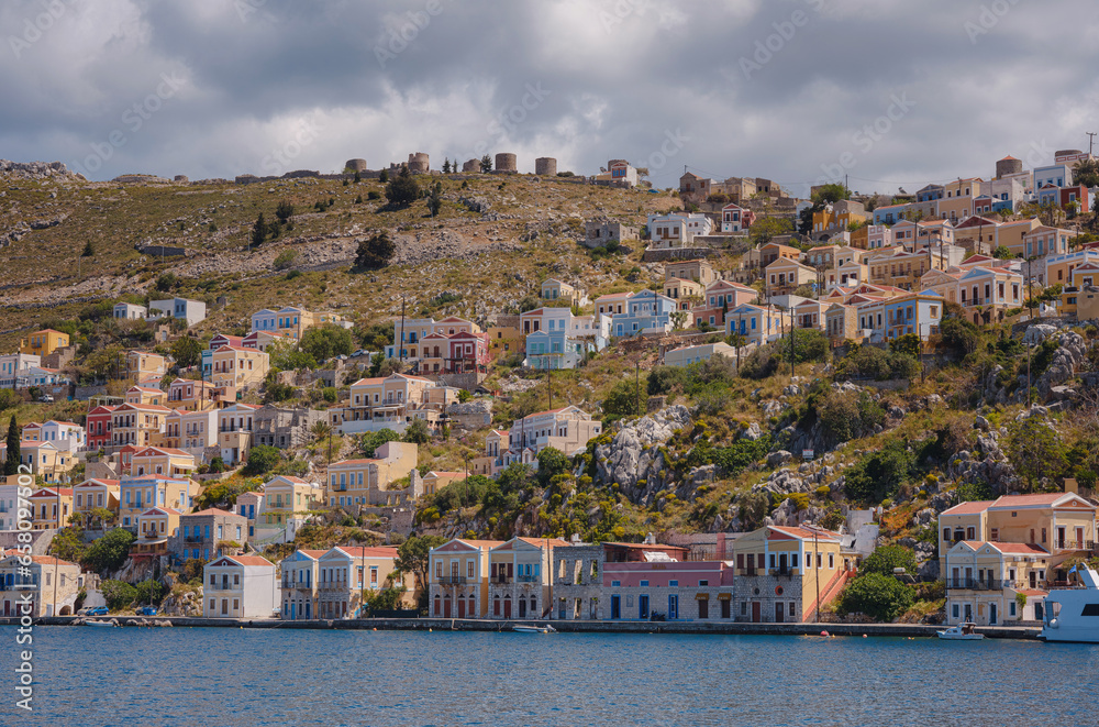 Symi Island, Greece. Greece islands holidays from Rhodos in Aegean Sea. Colorful neoclassical houses in bay of Symi. Holiday travel background.