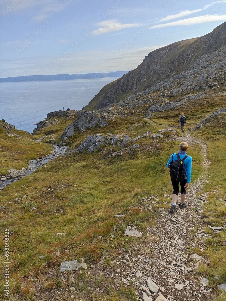 Two travelers hiking in the wild nature of Mageroya Island, Norway
