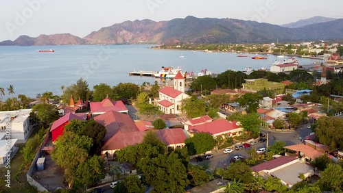Aerial view rising over Roman Catholic Motael Church and urban buildings, streets and trees in capital city of Dili, East Timor photo