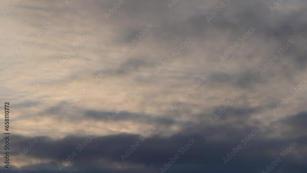 Plan fixe en accéléré de voile nuageux au coucher du soleil
