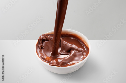 Pouring melted chocolate splash isolated on white clean table top background with clipping path.