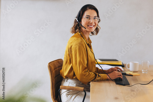 Professional call center agent working at her desk photo