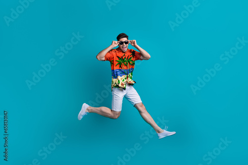 Full body size photo of crazy macho man youngster running jump trampoline having fun tourist journey isolated on blue color background