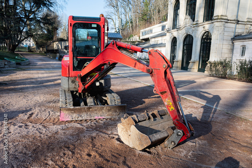 Small red excavator. Construction excavator in a construction site.