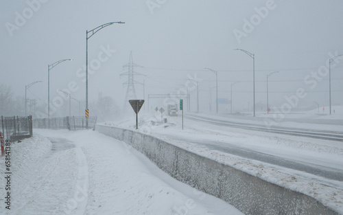 Road under the snow. Urban landscape in winter. City of Montreal under the snow. Winter storm in the city.Car covered with snow.Snow in the city - Snowstorm streetview.Canada,Quebec.