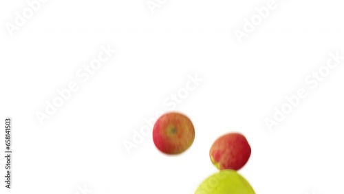 Green and red apples falling down in slow motion on white background.