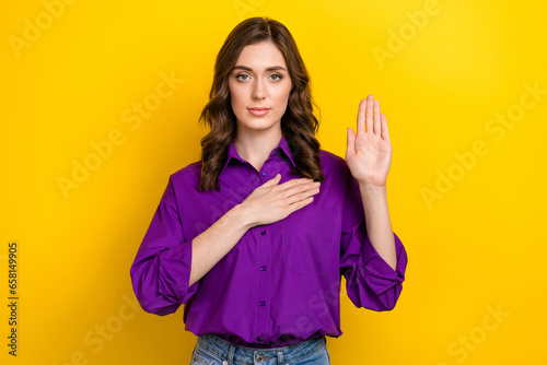 Photo of lovely calm young person arm touch heart raise palm swear promise isolated on yellow color background