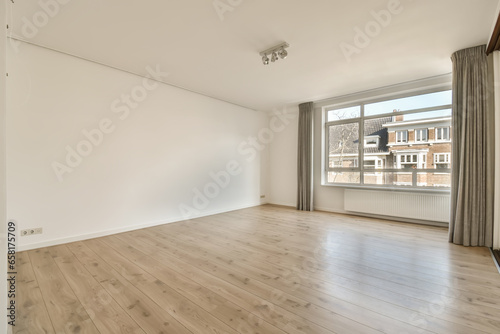 Empty living room with large window and white walls photo