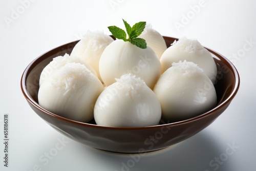 Homemade rasgulla with coconut flakes on it in a brown bowl isolated on white background photo