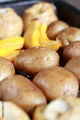 Potatoes baked on a baking sheet with zucchini. Shallow depth of field