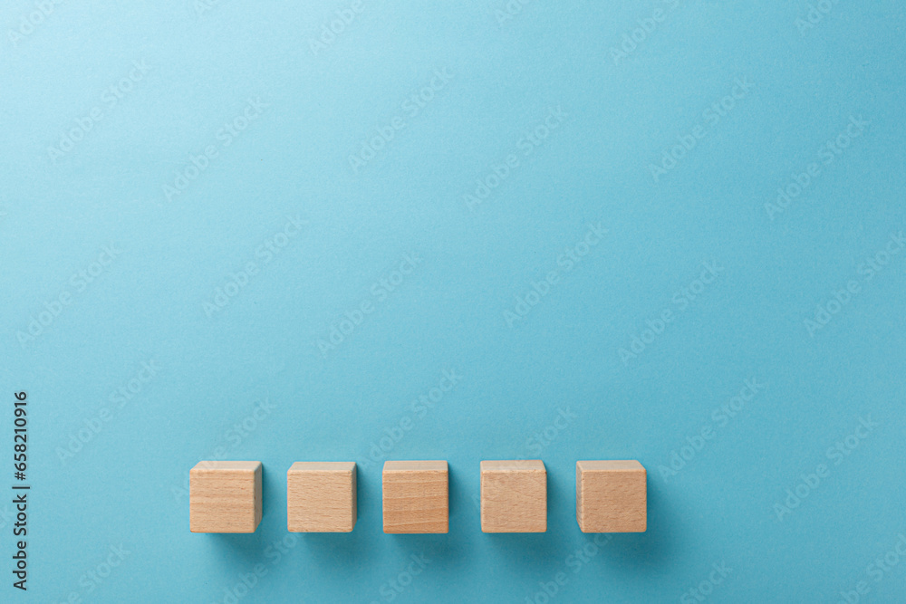 wooden cubes five pieces in a row on a blue background