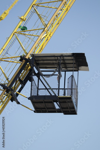 A crane with a cage on the side