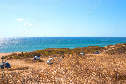 tourist camping with trailers and tents on the seashore on a sunny autumn day. Travel and tourism photo