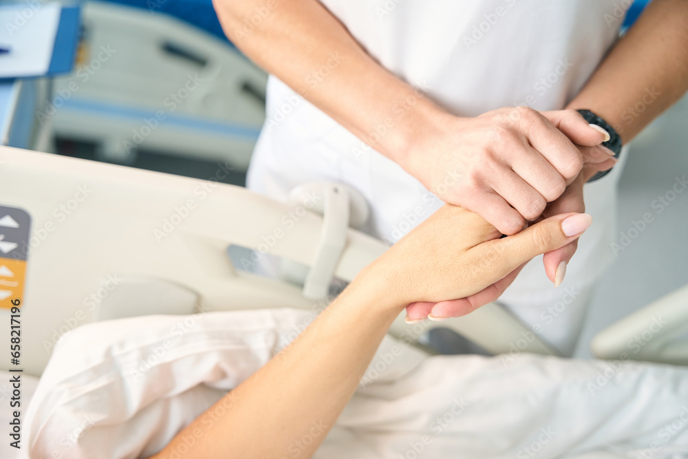 Nurse holds the patients hand