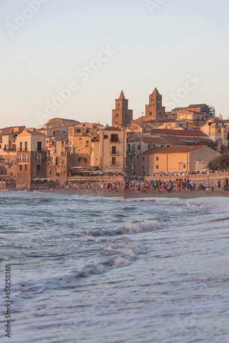 View of Cefalù, the city, the cathedral and its castle. Panorama seen from above of the whole landscape. Rough sea during sunset. The most beautiful places in Sicily. Excellent tourist destination.