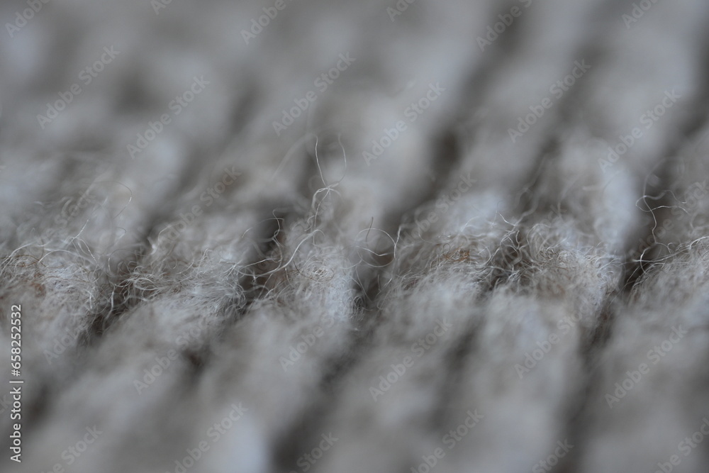 The texture of fabric thick beige sweater close-up. Knitted texture background The texture of fabric thick beige sweater close-up. Knitted texture background