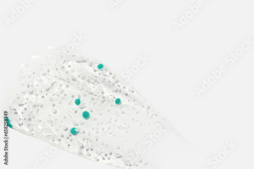 Smear  clear gel with blue granules  serum clear on a white background