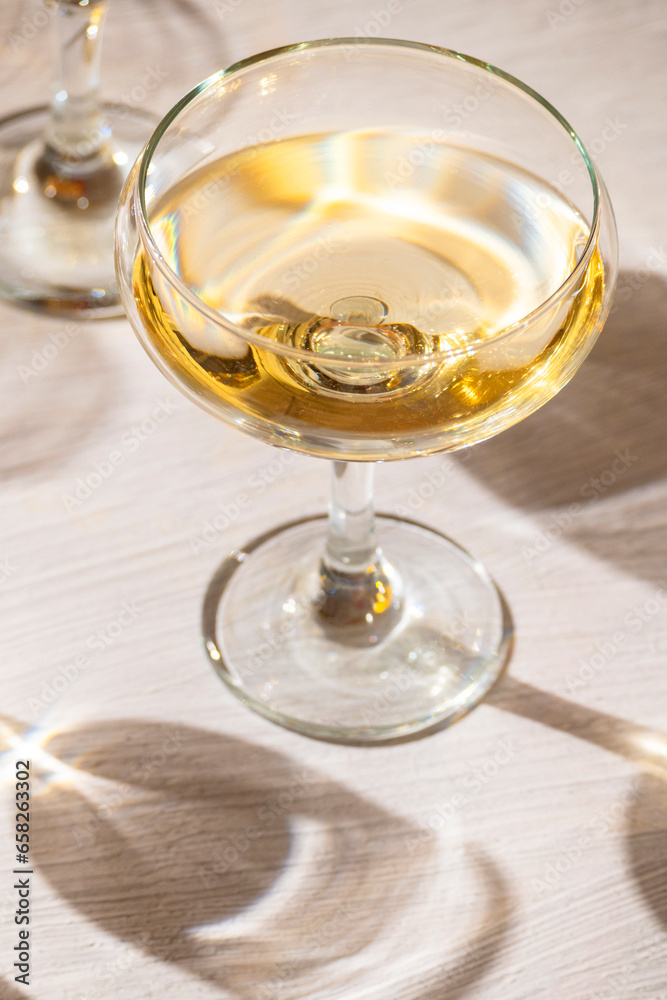 A glass with sparkling wine on the table, wine tasting, party and celebration concept, illuminating
A glass with sparkling wine on the table, wine tasting, party and celebration concept, illuminating