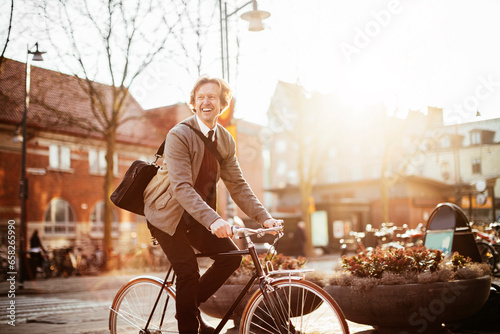 Mature businessman commuting to work on a bicycle in the city photo