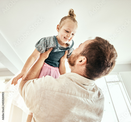 Family  children and a father carrying his girl daughter in the living room of their home together closeup. Smile  love or kids with a happy young child and her man parent having fun in their house