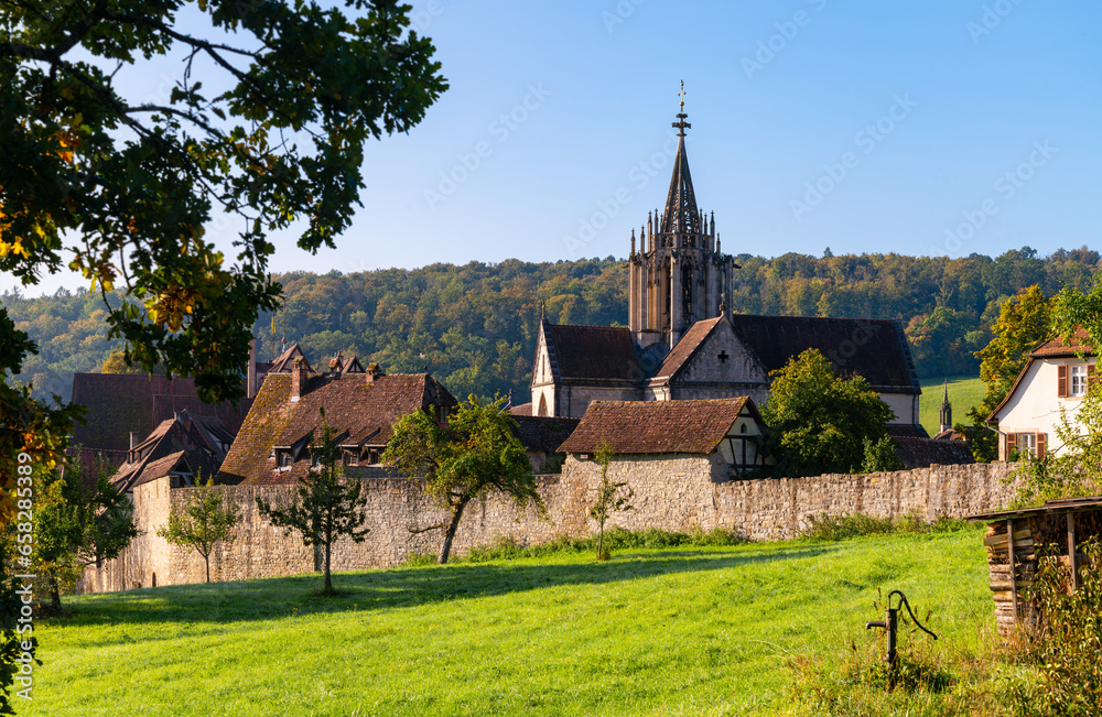 “Kloster Bebenhausen“ monastery and castle near Tübingen in southern Germany on a sunny late summer morning. Medieval landmark monument with church tower, old truss houses, walls in idyllic scenery.