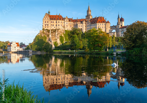 Sigmaringen castle is a historic monument and landmark in southern Germany on a rock in old town centre. Late summer evening panorma with reflection in river Danuve and water fowl. Tourist attraction. photo