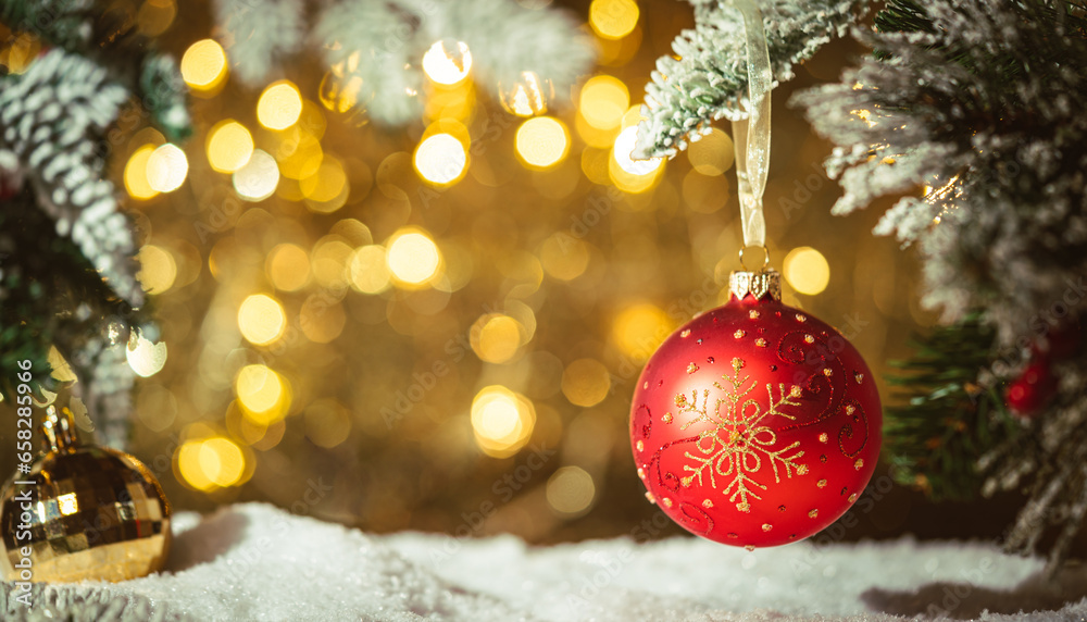 Christmas balls on fir branches with gold christmas lights in abstract defocused background