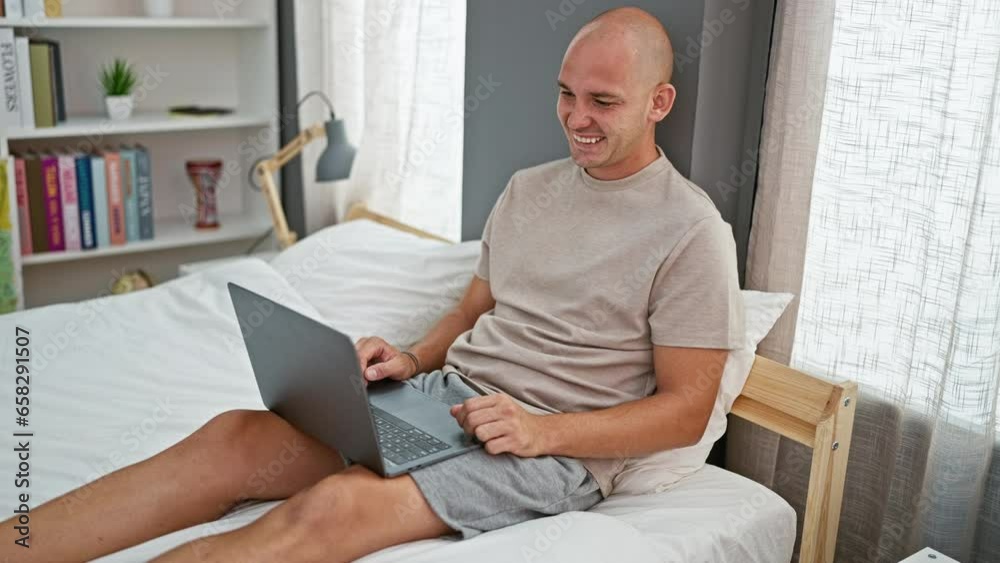 Young hispanic man doing video call with laptop sitting on the bed at bedroom Young hispanic man doing video call with laptop sitting on the bed at bedroom