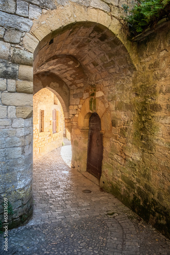 The ancient stone arched entrance to a castle that once stood below the Trogladytic Fort at La Roque-Gageac in the Dordogne region of France 