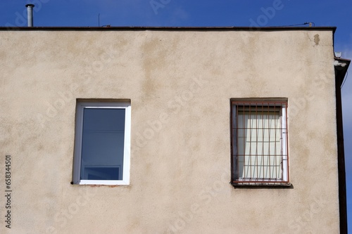 Low block building built of red brick with narrow windows replaced with new ones and one barred