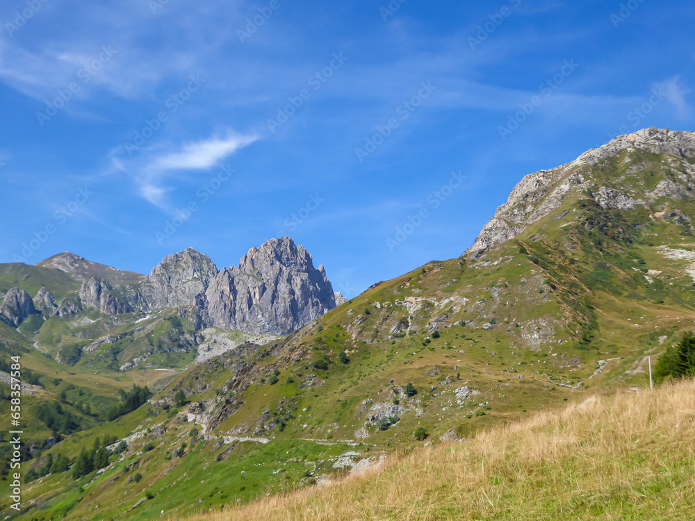 Panoramic mountain landscape of Cottian Alps in Grana Valley (Valle Grana) with clear blue sky on a sunny summer day, Castelmagno, Cuneo, Piedmont, Italy. Alpine pasture of Western Italian Alps
