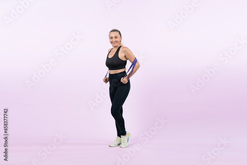 Full body length shot athletic and sporty senior woman with fitness resistance band on isolated background. Healthy active physique and body care lifestyle after retirement. Clout