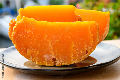 Pieces of native French aged cheese Mimolette, produced in Lille with greyish curst made by special cheese mites close up