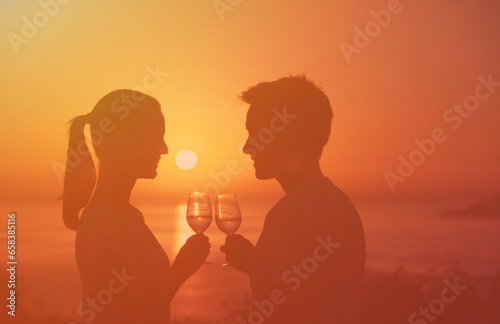 Man and woman enjoying wine and a beautiful ocean sunset 