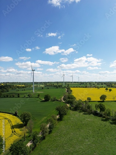 Lignes d'éoliennes au milieu des champs de colza photo