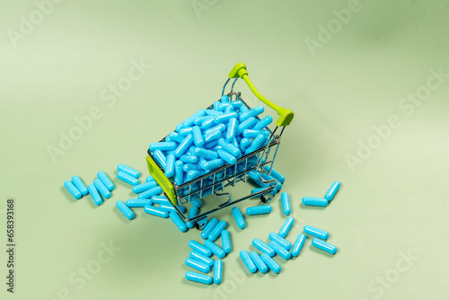 blue medicine capsule in miniature shopping cart © Celso Pupo