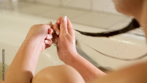 Young woman suffers from hair loss during shower. Hair loss concept photo
