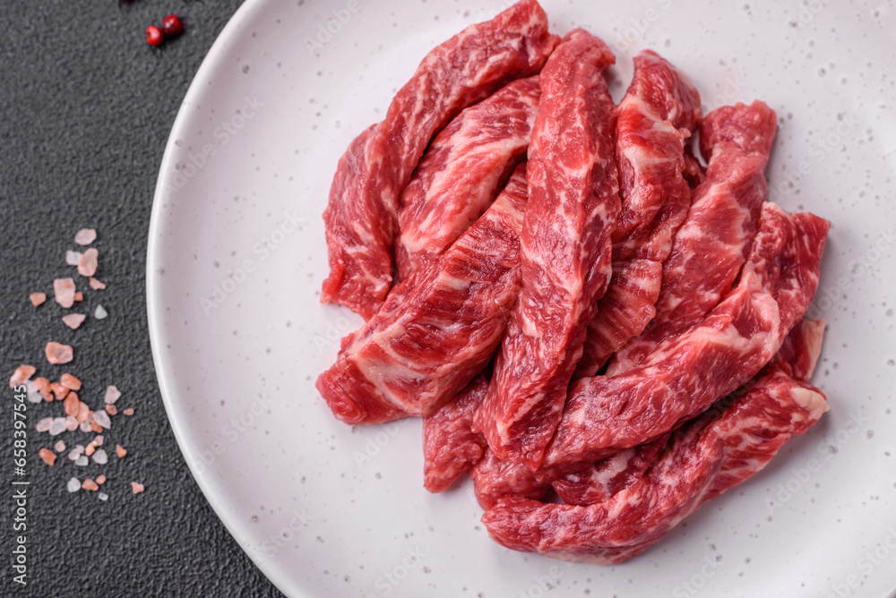 Fresh juicy raw beef slices with salt and spices Fresh juicy raw beef slices with salt and spices