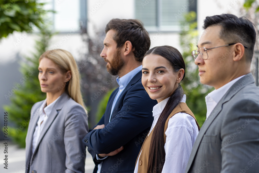 Portrait of a businesswoman from the outside of an office building, a female employee with a team of diverse business people on a work break. Portrait of a businesswoman from the outside of an office building, a female employee with a team of diverse business people on a work break.