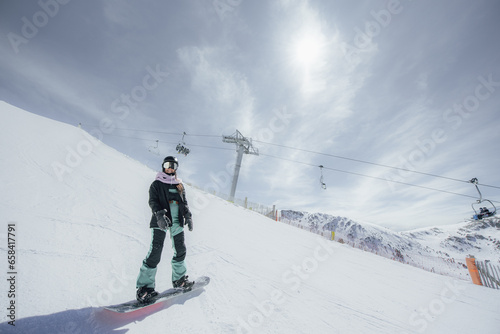 Woman in the mountains practicing snowboard. 
